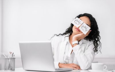 What Does the Bible Say About Quiet Quitting? Photo illustration of woman at work with paper open eyes taped over her eyes.